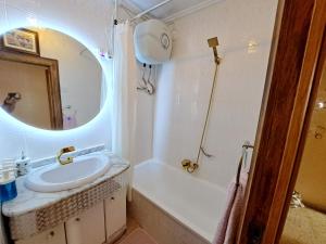 a bathroom with a sink and a tub and a mirror at 3 bedroom flat with wifi in Valencia