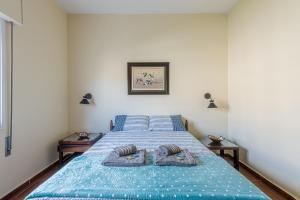 1 dormitorio con 1 cama con 2 toallas en Apê Clássico e Aconchegante no Guarujá - 350 m da praia, en Guarujá