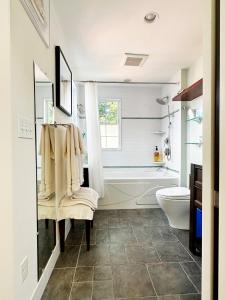 a bathroom with a tub and a toilet and a sink at Northey Street House in Salem