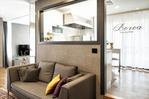 een woonkamer met een bank en een spiegel bij Borea Luxury B&B in Pescara