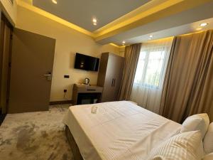 a bedroom with a white bed and a window at Istanblu Hotel Ataşehir in Istanbul