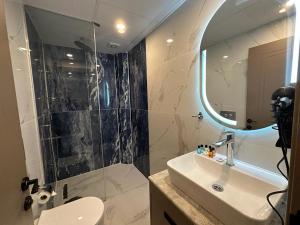 Istanblu Hotel Ataşehir في إسطنبول: حمام مع حوض ودش مع مرآة