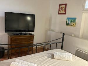 um quarto com uma televisão de ecrã plano e uma cama em Le Cardinale - Un Voyage en Provence - 2 chambres avec parking em Aix-en-Provence