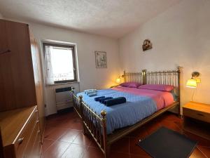 una camera da letto con un letto con lenzuola viola e una finestra di Appartamento Fiore Rocca a Rocca di Mezzo