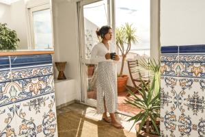 a woman standing in a room with a window at Olympo Shared flat with Amazing River view in Lisbon