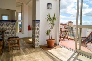 a living room with a potted plant and a balcony at Olympo Shared flat with Amazing River view in Lisbon