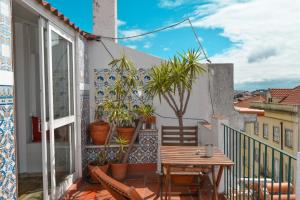 a balcony with a wooden table and potted plants at Olympo Shared flat with Amazing River view in Lisbon