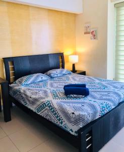 a bedroom with a bed with a blue and white comforter at Vacaciones Playa Azul in Tonsupa