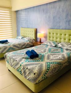 2 camas con almohadas azules en un dormitorio en Vacaciones Playa Azul, en Tonsupa