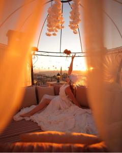 a woman in a white dress laying on a bed at Maya Cave in Uchisar