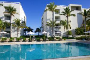 una piscina frente a un hotel con palmeras en Le Vele Resort, en Grace Bay