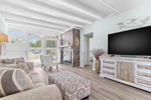 sala de estar con TV de pantalla plana grande en Madeira Beach Retreat en St Pete Beach