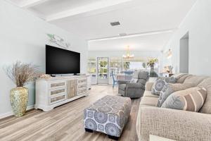 sala de estar con sofá y TV en Madeira Beach Retreat en St Pete Beach