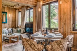 a living room with a table and chairs and a couch at Appartement FORNET à l'Hôtel LE VAL D'ISERE in Val dʼIsère