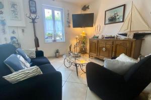 salon z 2 niebieskimi krzesłami i stołem w obiekcie Gîte Etienne Marie w mieście Le Crotoy