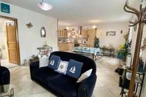 salon z czarną kanapą z poduszkami w obiekcie Gîte Etienne Marie w mieście Le Crotoy