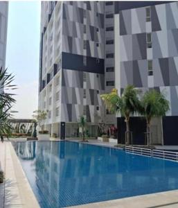 a swimming pool in front of a tall building at PANGSAPURI MIDAS in Johor Bahru