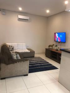 sala de estar con sofá y TV de pantalla plana en Attriun Hotel, en Guarulhos