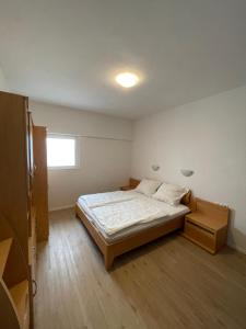 um pequeno quarto com uma cama e uma janela em 70qm Apartment für sie und ihre Familie 