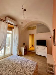 um quarto com uma cama e uma cómoda com uma televisão em In The Heart Of Naples em Nápoles