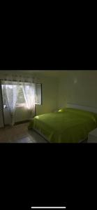 um quarto com uma cama verde e uma janela em Iezza Residence em San Polo Matese