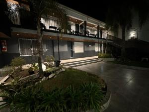 un patio de un edificio por la noche con balcón en Posada del Angel en Villa Carlos Paz