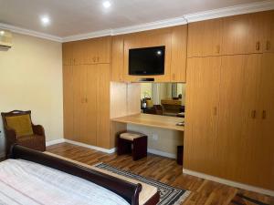 - une chambre avec un lit, un bureau et une télévision dans l'établissement Upper Room Guesthouse, à Kirkwood