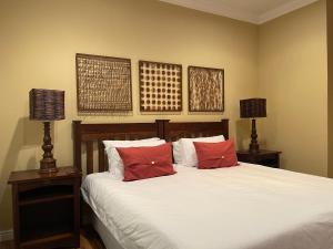 a bedroom with a bed with red pillows and two lamps at Upper Room Guesthouse in Kirkwood