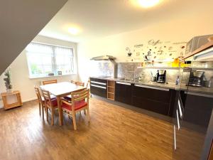 a kitchen with a table and chairs in a room at Die Ostseeperle mit Pool 2 in Barendorf