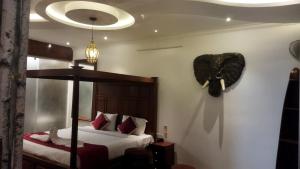 a bedroom with a bed and a fan on the wall at Zoom Inn Heritage in Puducherry