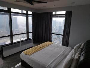 a bedroom with a bed and large windows at Bintang Royal Casa Suites Times Square KL in Kuala Lumpur