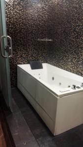 a white bath tub in a bathroom with a wall at Zoom Inn Heritage in Puducherry