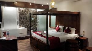 a bedroom with a canopy bed in a room with a window at Zoom Inn Heritage in Puducherry +16 photos