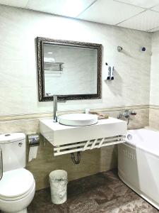 An KhêにあるHotel Nam Sơnのバスルーム(洗面台、トイレ、鏡付)