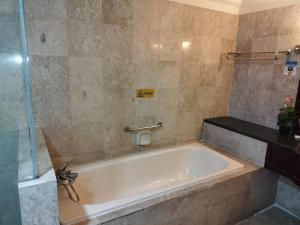 a bath tub in a bathroom with a shower at Bintang Royal Casa Suites Times Square KL in Kuala Lumpur +63 photos