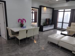 a living room with a table and chairs and a couch at Bintang Royal Casa Suites Times Square KL in Kuala Lumpur
