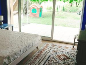 une chambre avec un lit et une porte coulissante en verre dans l'établissement Grande maison familiale 4 chambres, 140m², proche forêt, terrasse et jardin clos, Biscarrosse - FR-1-521-22, à Biscarrosse