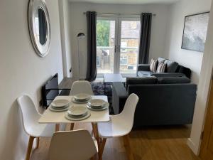 uma sala de estar com uma mesa e cadeiras e um sofá em Stylish and Modern 2BR Apartment with Parking em Sheffield