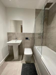 a bathroom with a toilet and a sink and a shower at Stylish and Modern 2BR Apartment with Parking in Sheffield