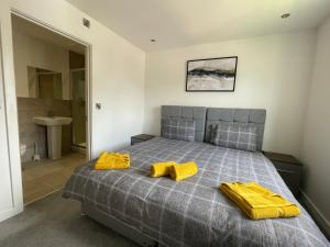 a bedroom with a bed with yellow towels on it at Stylish and Modern 2BR Apartment with Parking in Sheffield