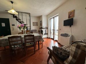 un soggiorno con tavolo, sedie e TV di Appartamento Fiore Rocca a Rocca di Mezzo