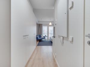 a hallway with white cabinets and a blue couch at SPOT Apartments - Turun satama in Turku