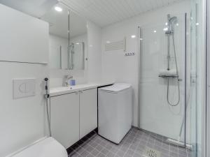 a white bathroom with a shower and a toilet at SPOT Apartments - Turun satama in Turku