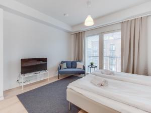 Cette chambre comprend deux lits et une télévision. dans l'établissement SPOT Apartments - Turun satama, à Turku