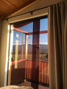 a room with a window with a view of the mountains at Chalé vista da serra in Delfinópolis