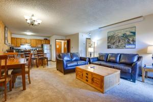 a living room with blue leather furniture and a dining room at Mtn Condo with Ski Locker and Pools - 3 Mi to Resort! in Winter Park
