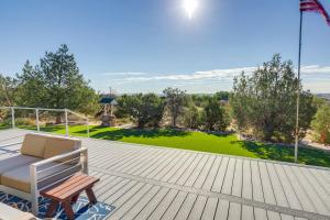 una terraza de madera con un banco y un patio verde en Home with Views and Fire Pit, 10 Mi to Aztec Ruins! en Farmington