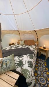 a bedroom in a tent with a bed and pillows at La Colmena Glamping in El Rosario