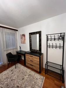 a desk with a mirror and a chair in a room at Vilmos apartman in Pécs