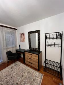 Habitación con escritorio con espejo y silla. en Vilmos apartman, en Pécs
